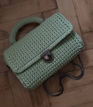 Handmade sage-green crochet top-handle bag with a black-nickel turn-lock clasp and a chain shoulder strap