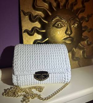 Handmade white crochet bag with a gold clasp and chain strap